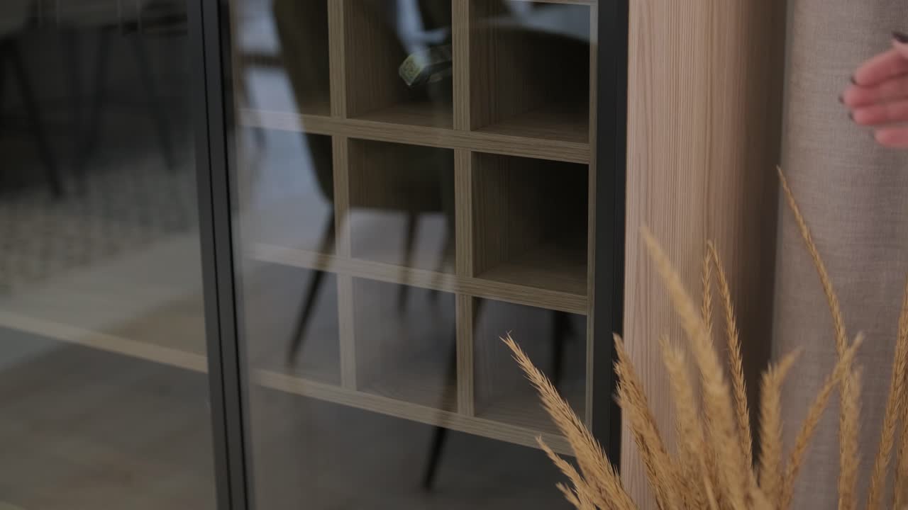 la chica enciende la luz en el armario del vino usando el botón táctil