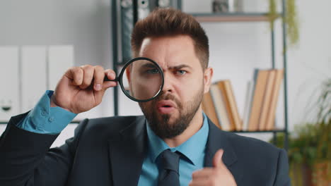 business man holding magnifying glass near face, looking with big zoomed eye, searching, analysing