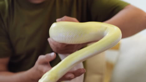 man holding snake indoors