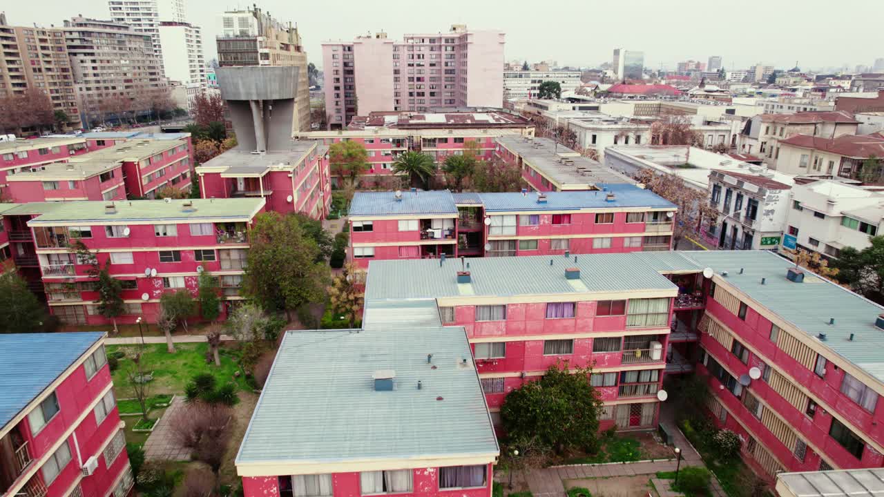 Flyover over residential and old buildings in downtown Santiago, Chile with 70's architecture, water storage tank on the roof