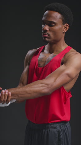 vertical video of male boxer with hands wrapped in protective bandages sparring before boxing match or training session