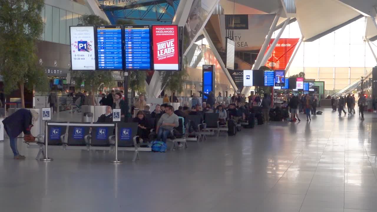 Interior of new modern terminal at Lech Walesa Airport in Gdansk. Arrival departure board at the terminal.People waiting in the terminal