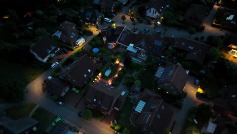 luxury american residential area with single family homes and swimming pool in garden. aerial top down rising shot. lighting warm lantern and streetlamps. proud suburb city in united states.