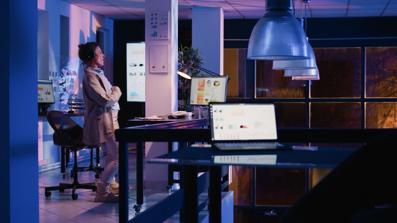 Kvinde, der arbejder sent på kontoret og analyserer data