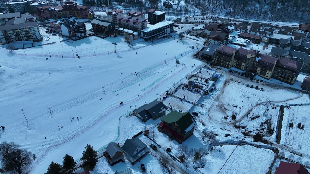 una estación de esquí cubierta de nieve con esquiadores en las laderas, ascensores de esquí y una bulliciosa atmósfera de deportes de invierno