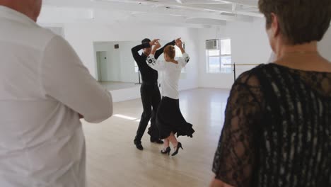 mixed race male dance teacher taking a ballroom dancing class at a dance studio