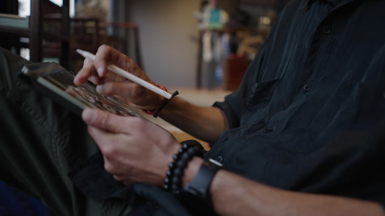 En person bruger en tablet med en stylus.