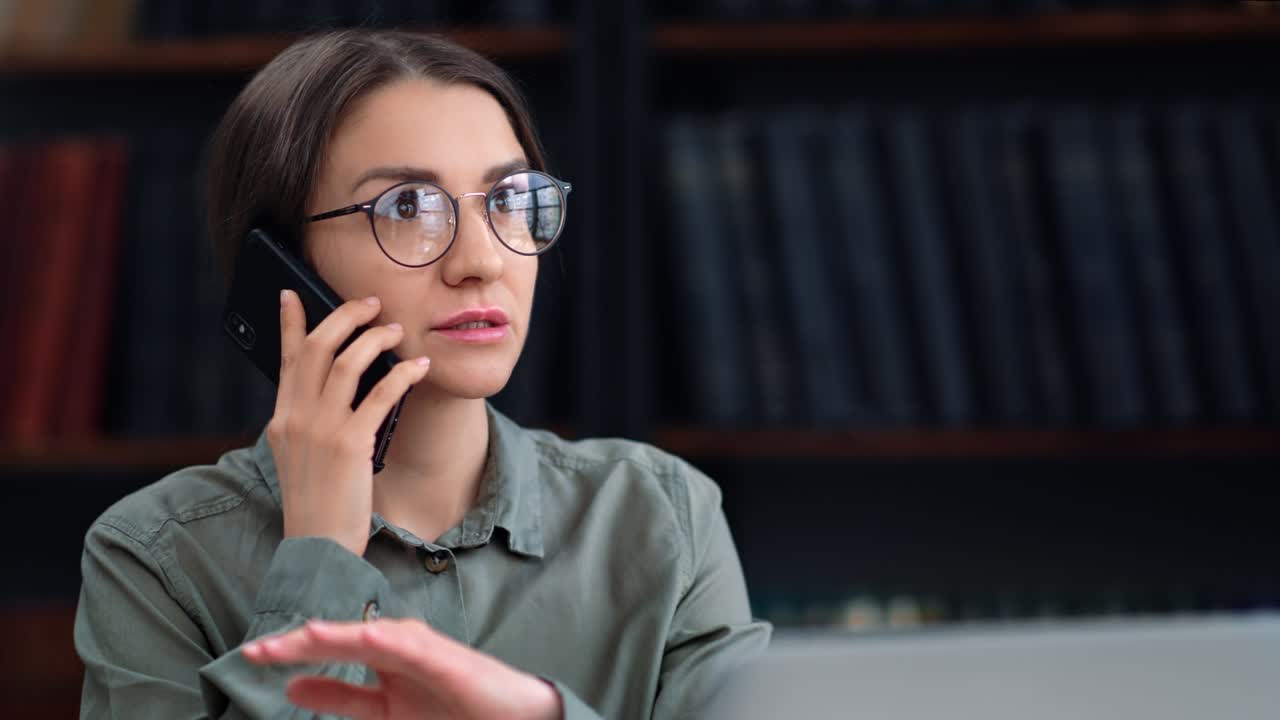 Business woman talking smartphone working laptop discussing project partner at library room closeup