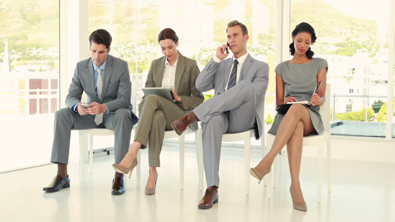 사업가들이 앉아서 기다리고 있습니다.