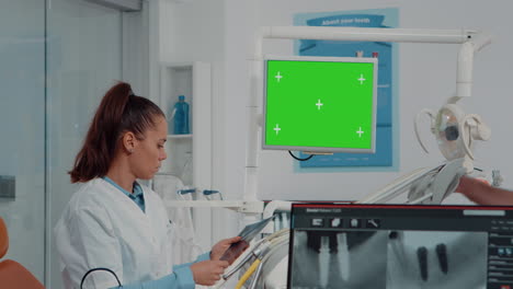 woman working as dentist with green screen and x ray scan