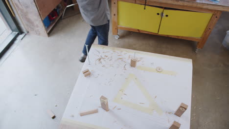 Fotografía-Cenital-De-Un-Artesano-En-Un-Taller-De-Montaje-De-Un-Cuadro-De-Bicicleta-De-Bambú-Sostenible-Construido-A-Mano.