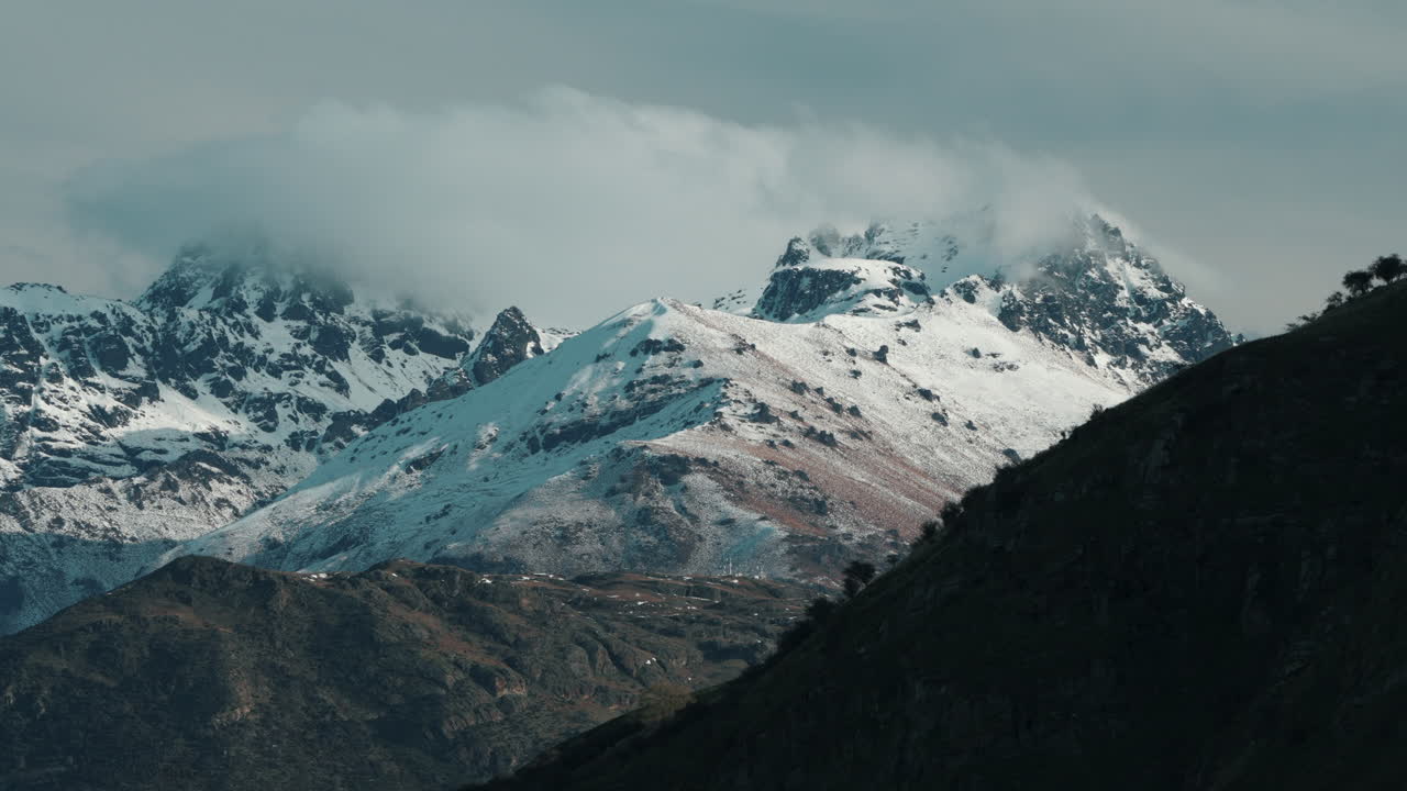 vista panorámica de nubes y montañas cubiertas de nieve durante el invierno en queenstown, nueva zelanda