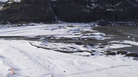 Aerial-establishing-shot-of-parachuters-landed-within-a-frozen-Icelandic-valley