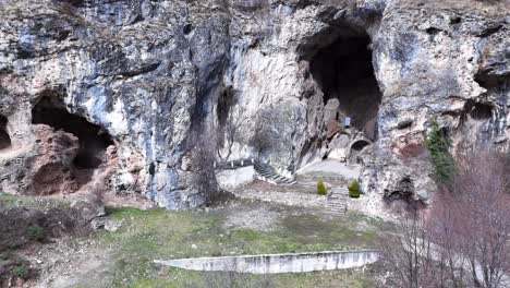 vista aérea desde un avión no tripulado de una antigua capilla ortodoxa construida en la cueva y cuevas cercanas | 4k