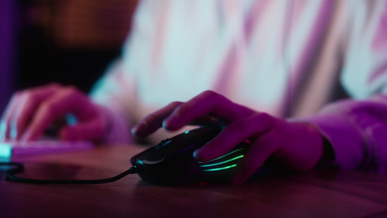 Detail of computer mouse used by gamer at night