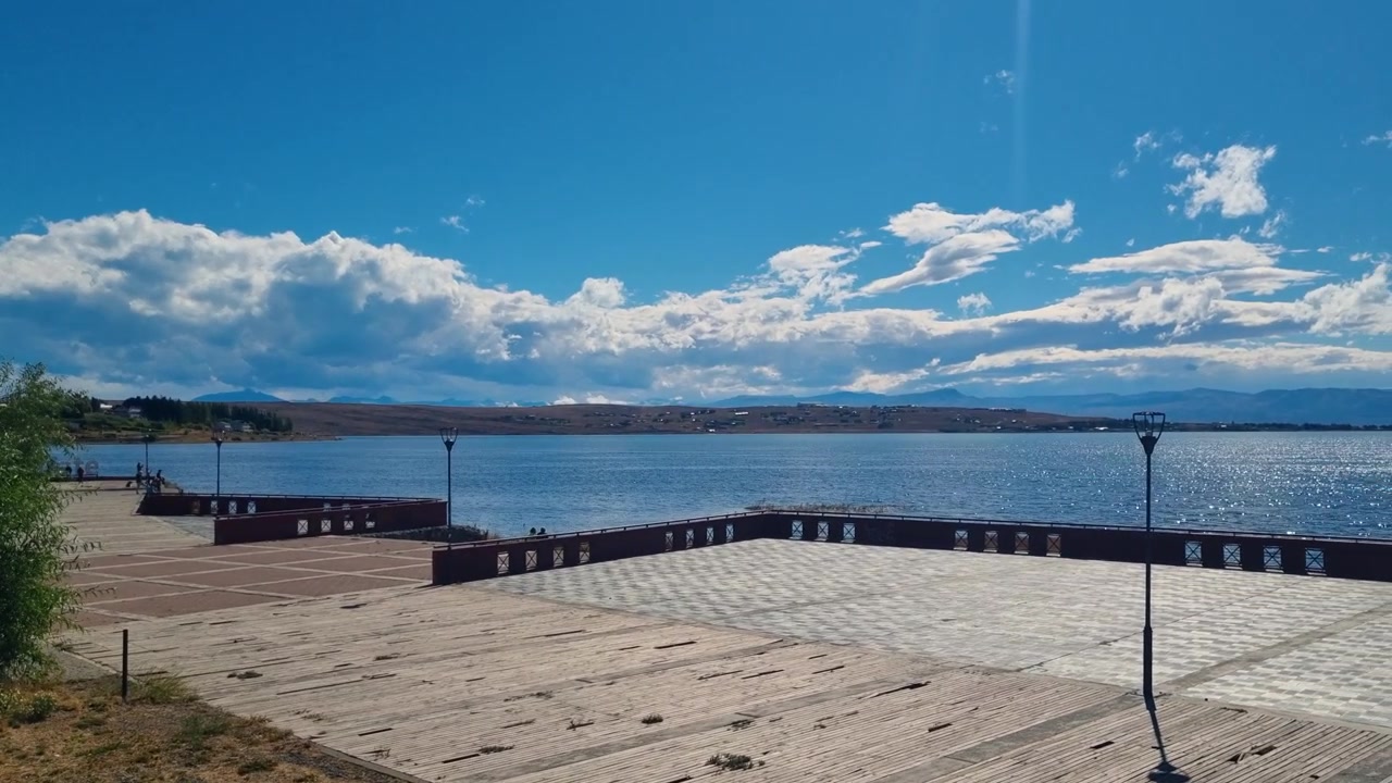Rantapromenadi Lago Argentino -järven rannalla El Calafatessa, Argentiinassa, tarjoten laajat näkymät koskemattoman jäätikköjärven yli kirkkaan sinisen taivaan alla.