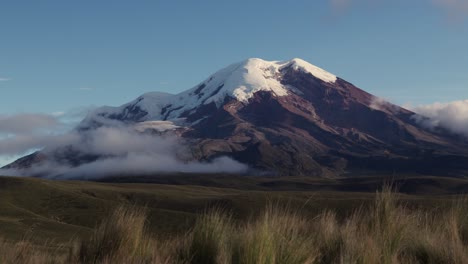 drone overview of volcan chimborazo in ecuador with clouds swirling around the summit