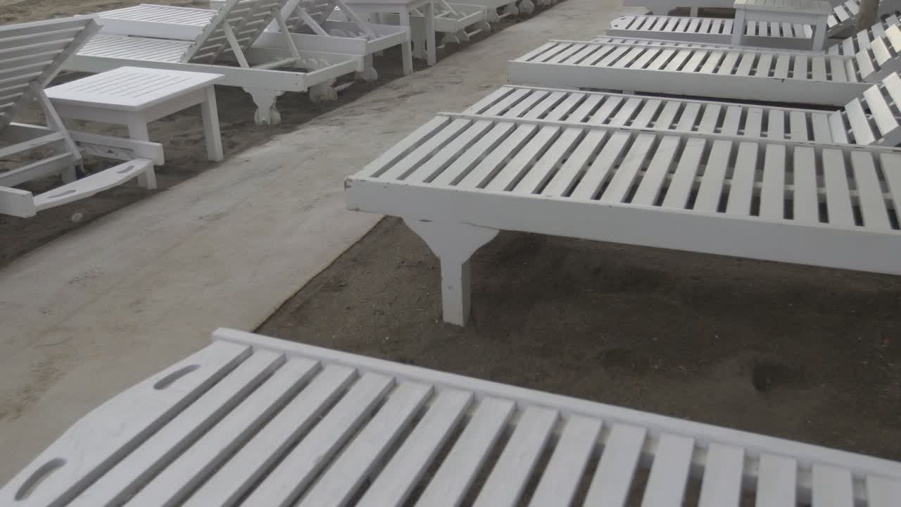 일몰, 골든 마일, 마르베야, 말라가, 스페인, 코스타 델 솔(costa del sol)로 알려진 아름다운 휴가지의 푸엔테 로마노(puente romano) 앞 해변에 있는 일광욕용 침대와 짚으로 만든 파라솔을 천천히 감상하세요.