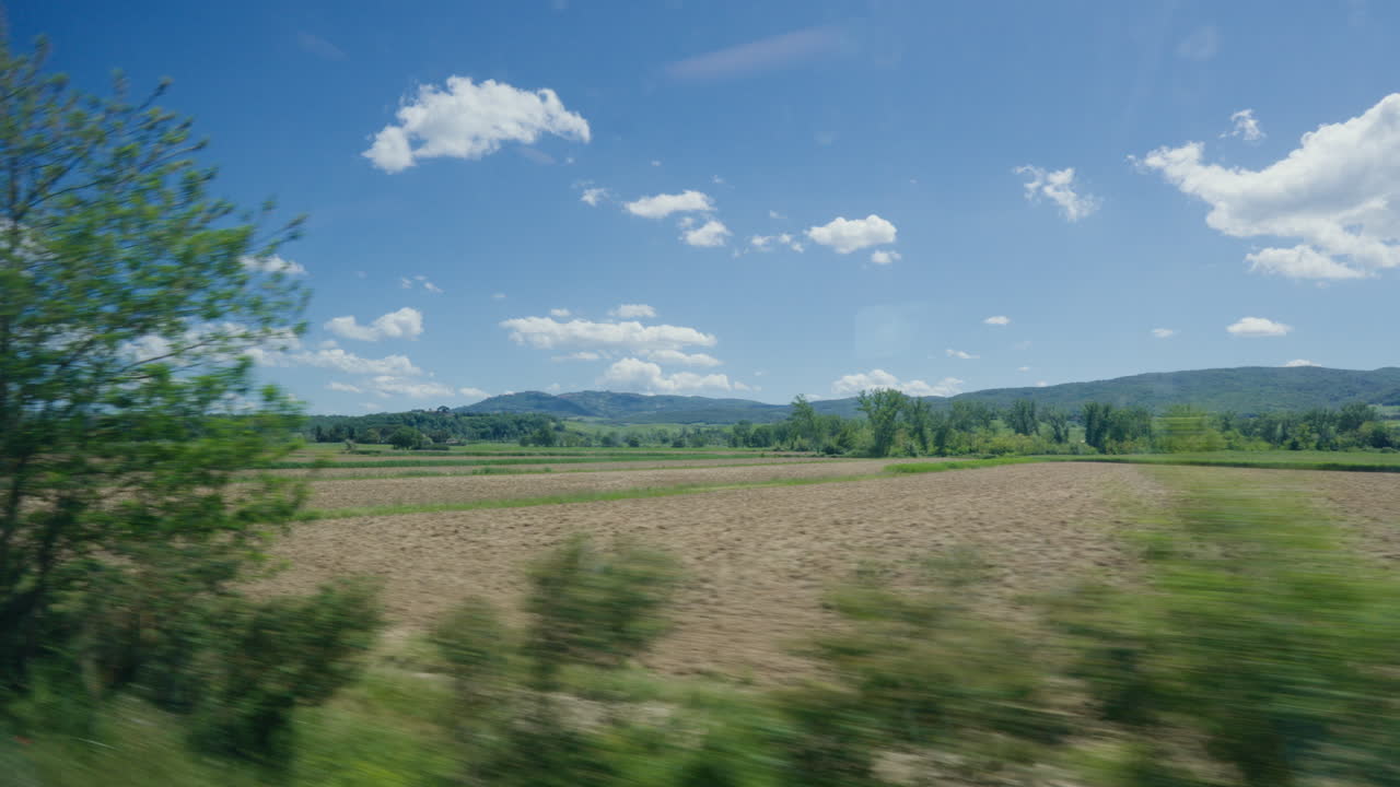 paisaje pintoresco de la toscana desde un vehículo en movimiento, cielos azules por encima
