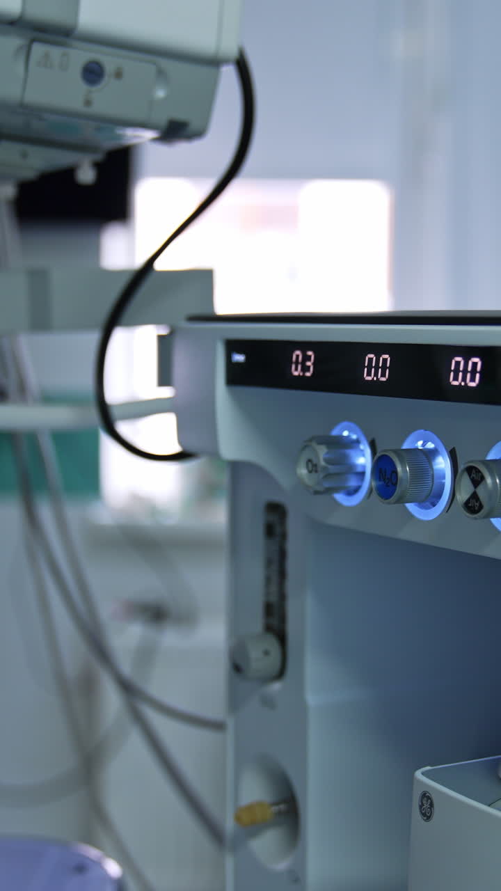 Hand of a doctor turning the handles on the medical equipment. Artificial lung ventilation system in modern operational room. Vertical video