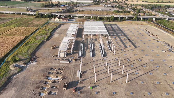 Große Logistikanlage im Bau, Stahlrahmen für Lagerhallen, Betonfundamente, Stützpfeiler, Baumaschinen und Verkehrsinfrastruktur, Drohnen-Slide