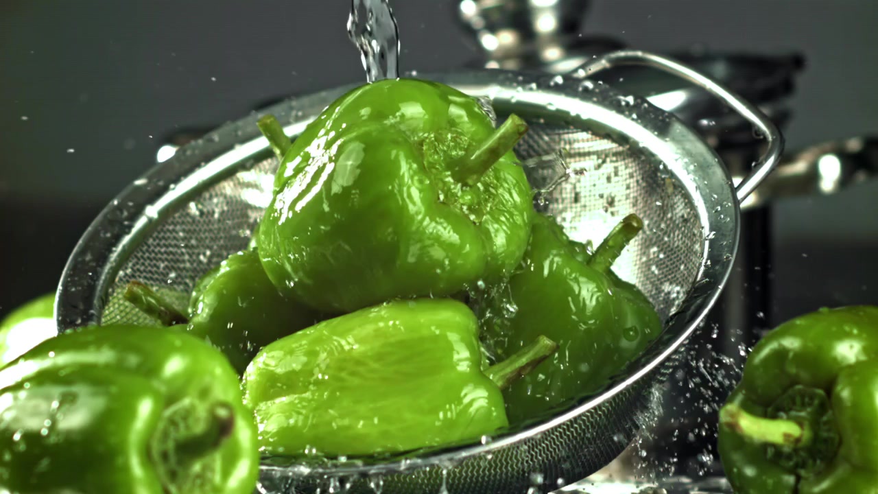 Verse groene paprika's worden gewassen in een vergiet