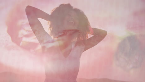 woman raising arms behind head in fashion studio portrait, smiling with pink ripple overlay