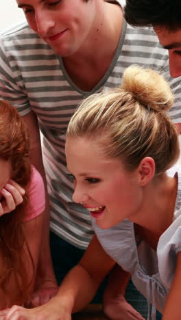 cheerful young students using laptop together