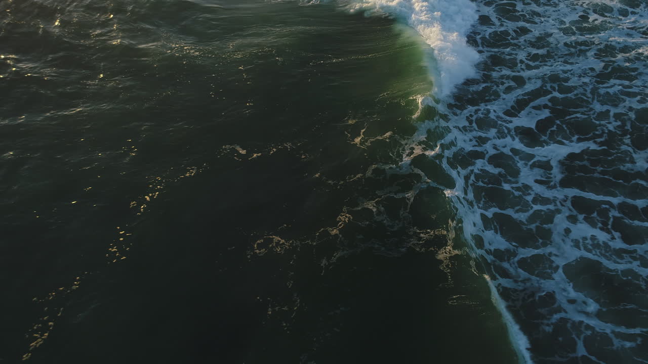 Vista aérea das ondas do oceano com o sol da manhã refletindo na água ao nascer do sol em Miami Beach, Gold Coast, Austrália.
