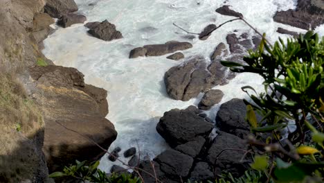 Olas-Lavando-Las-Rocas-En-La-Base-De-Una-Montaña