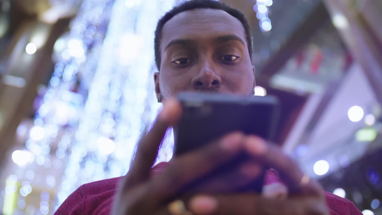 Man using smartphone in a shopping mall