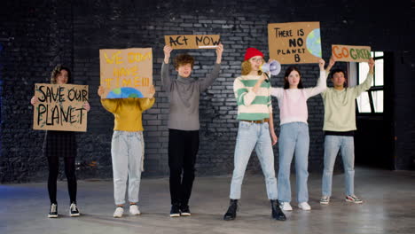 young environmental activists with placards and megaphone protesting against climate change inaction