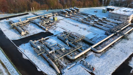 gas pipeline operational plant at wallbach switzerland in snow, drone down pedestal tilting shot