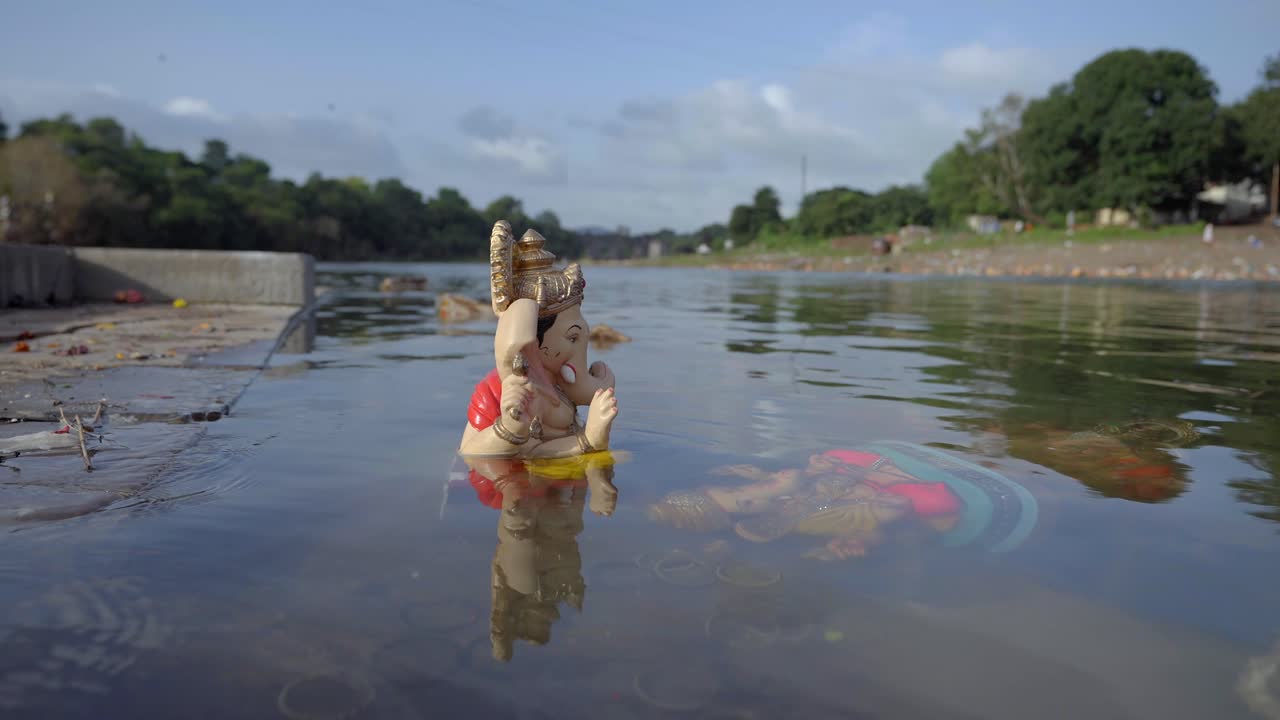 Tradizione del Ganesh Visarjan nel fiume Krishna a Satara, in India