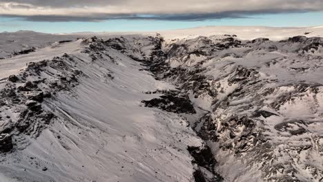 Aerial-landcsape-view-over-mountains-near-Sólheimajökull-glacier,-in-Iceland-at-dusk