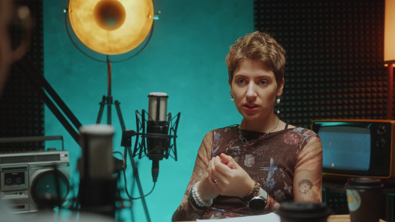 Female Influencer Giving Interview to Podcast Host in Recording Studio