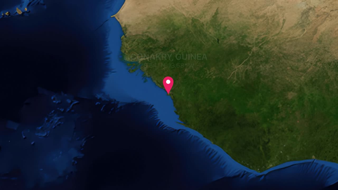 A digital earth render zooms from a global view into Conakry Guinea with location pin