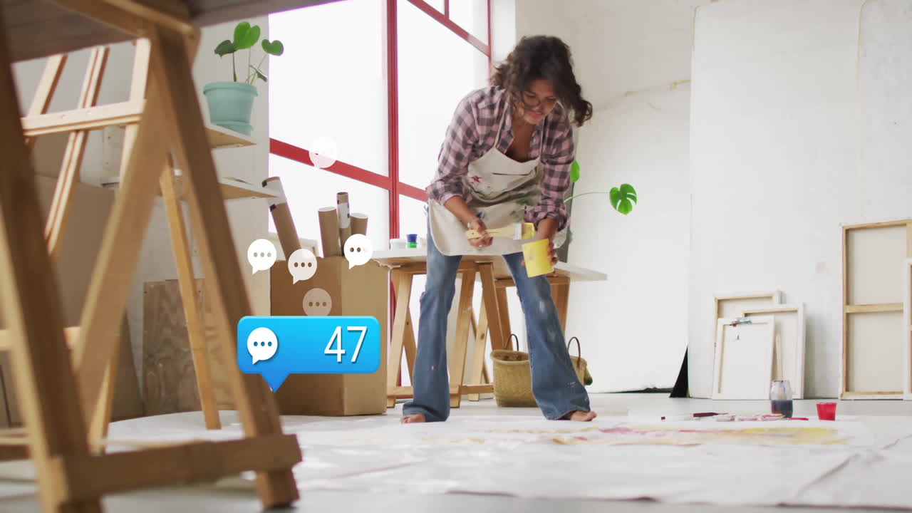 woman painting on floor canvas in art studio, showcasing animated paint droplets and color swatches