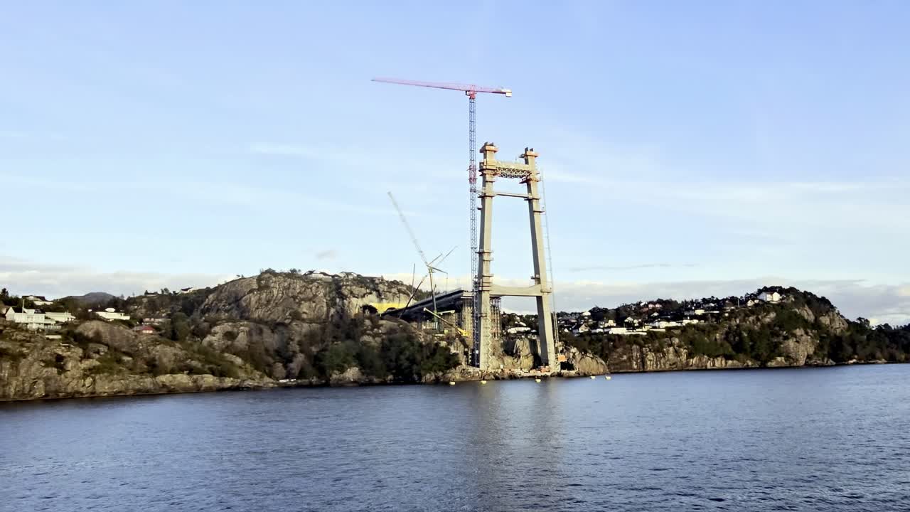 Tekne, arkasında tünel girişi olan Sotra Link köprü kulesine ve vinçlere doğru yavaşça ilerliyor.