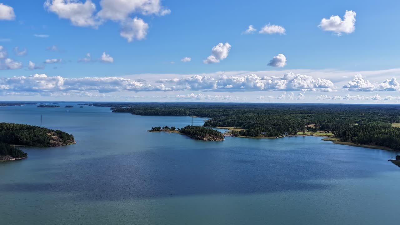 Drone hyperlapse over Finnish Turku Archipelago Sea. Sunny summer weather. Clouds and shadows moving over the scenery. High altitude moving aerial view