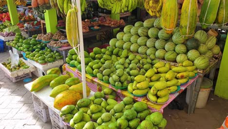 A-variety-of-tropical,-exotic-fresh-fruits-and-vegetables-including-mangoes,-papaya-and-water-melon-on-market-stall-in-capital-Dili,-Timor-Leste,-Southeast-Asia