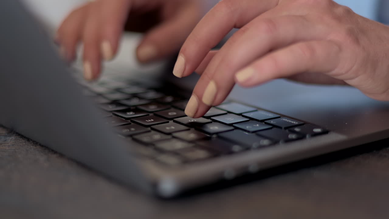 Primo piano di una donna che digita su un laptop alla scrivania in un ufficio