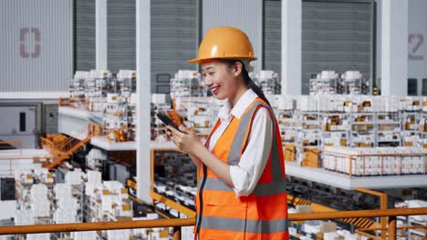 mujer trabajadora en un almacén usando un teléfono inteligente