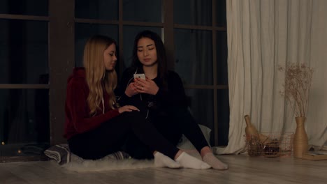 girlfriends sharing on line music with earphones