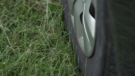 close up of a car wheel parked on green grass