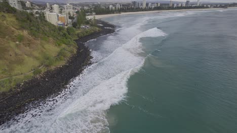 Foamy-Waves-Splashing-On-The-Rocky-Shore-Of-Burleigh-Beach-In-Gold-Coast,-Australia---aerial-drone-shot