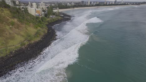 Olas-Espumosas-Chapoteando-En-La-Costa-Rocosa-De-La-Playa-De-Burleigh-En-Gold-Coast,-Australia---Disparo-Aéreo-De-Drones