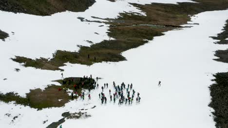 group of people resting together during hike on snowy slope in iceland