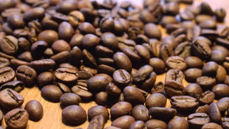 roasted coffe beans falling on wooden table to scatter