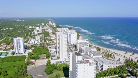 aerial flyover luxury apartment blocks with caribbean sea view at playa juan dolio in marbella during sunny day